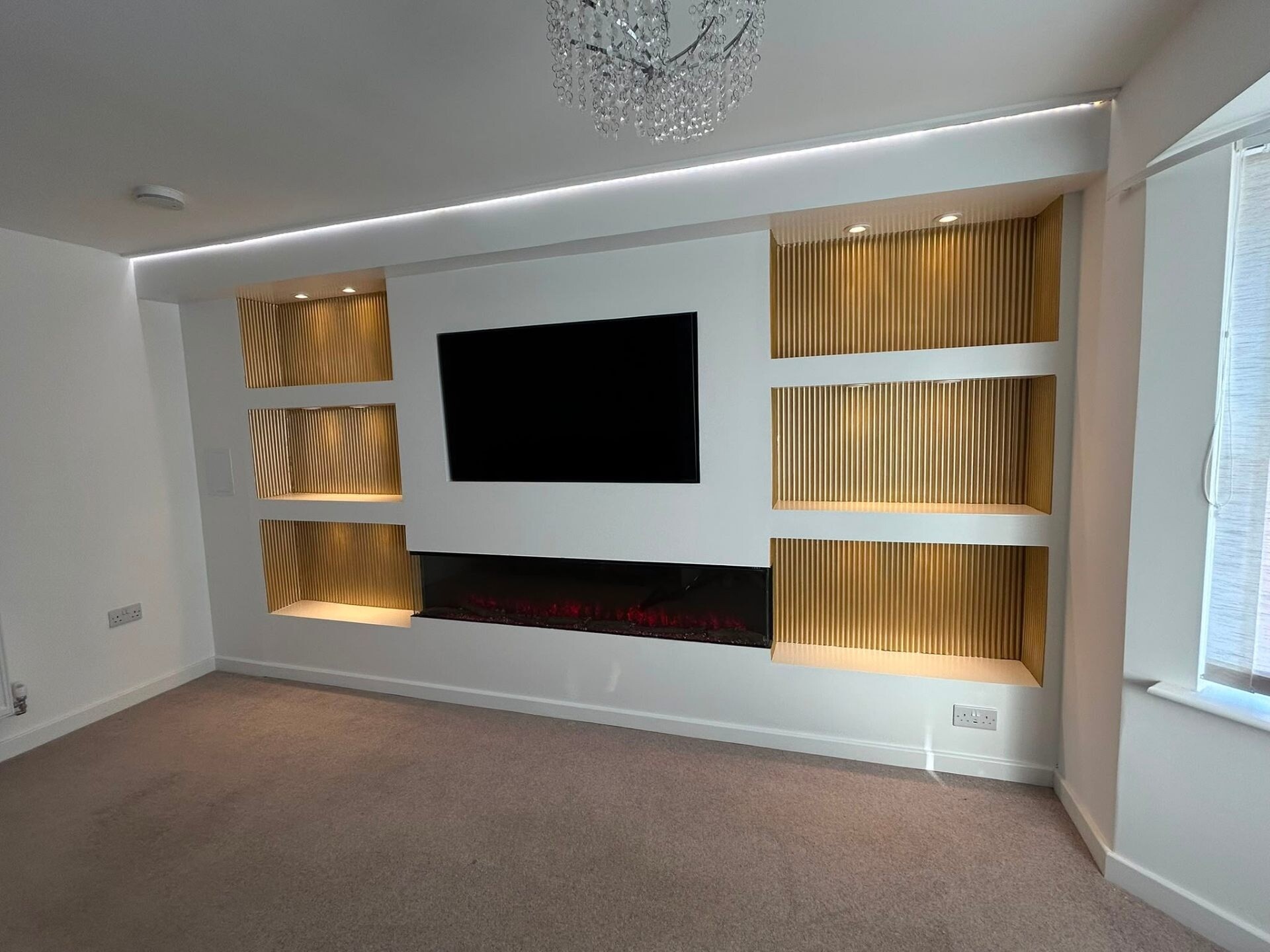 Contemporary white media wall with reeded oak shelving and feature TV.