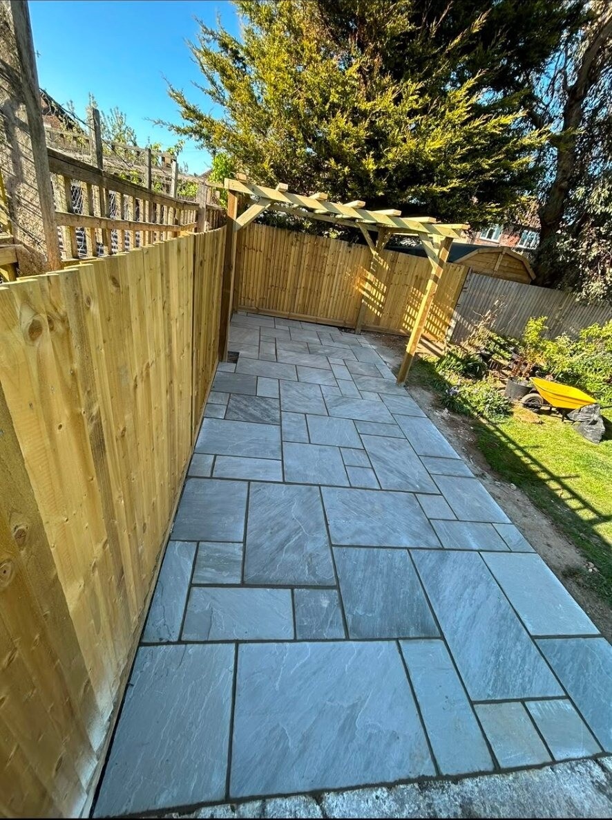 Riven sandstone patio path running alongside fencing and a side-return garden.