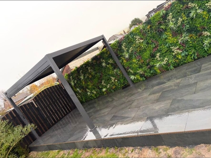 Pergola and patio with artificial green-wall screening in a Sussex back garden.