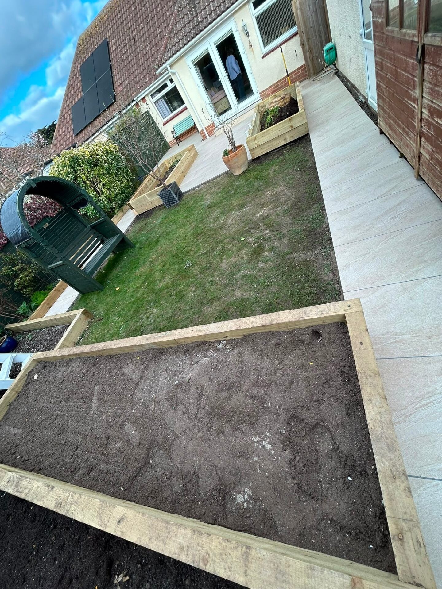 Porcelain patio laid edge-to-edge with a manicured rear lawn.