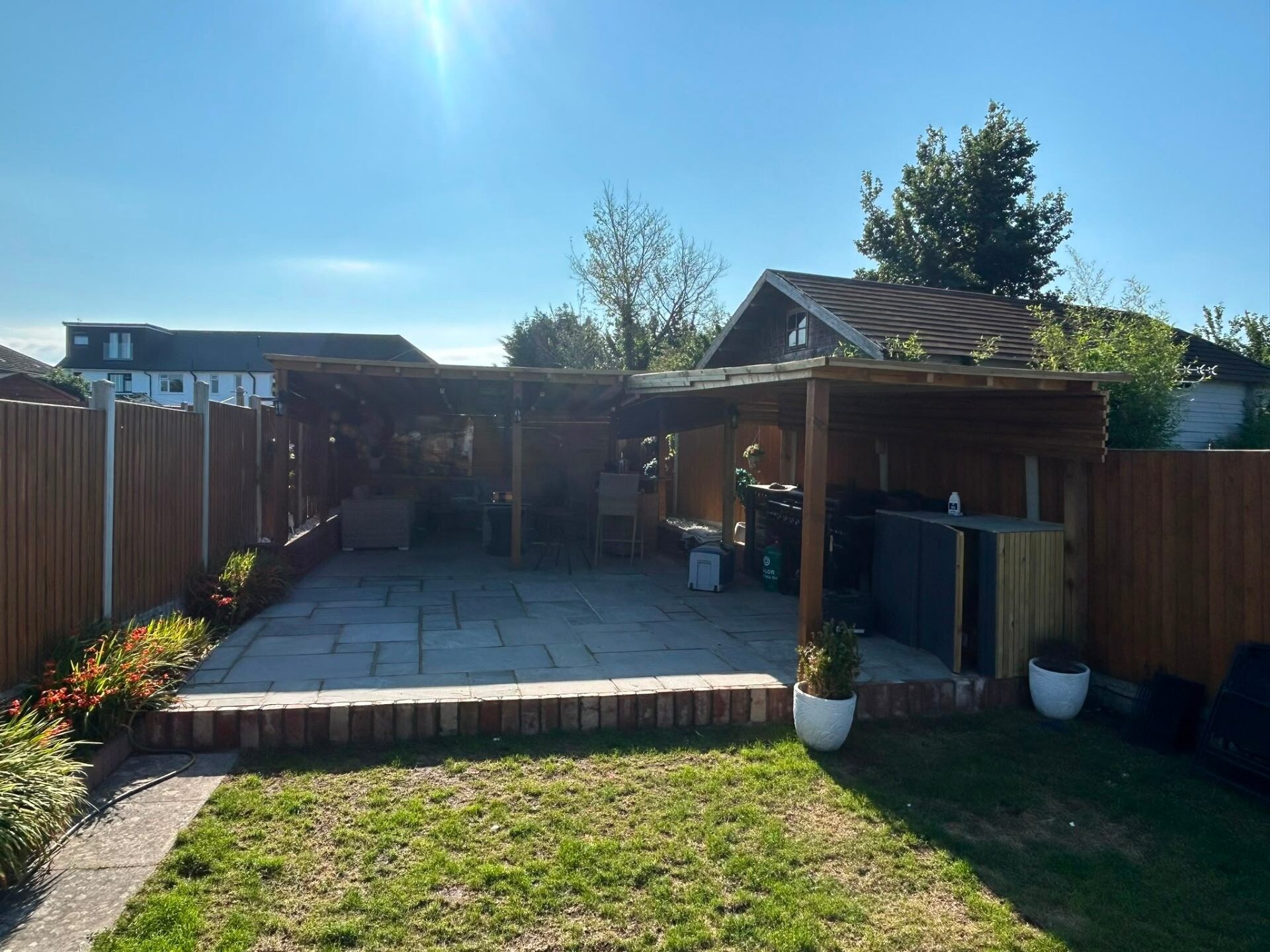 Full back-garden redesign with new patio, lawn and timber outbuilding.