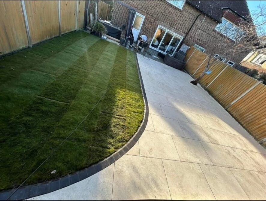 Full garden transformation in West Sussex with fresh striped lawn, brick mowing edge and large-format porcelain patio.