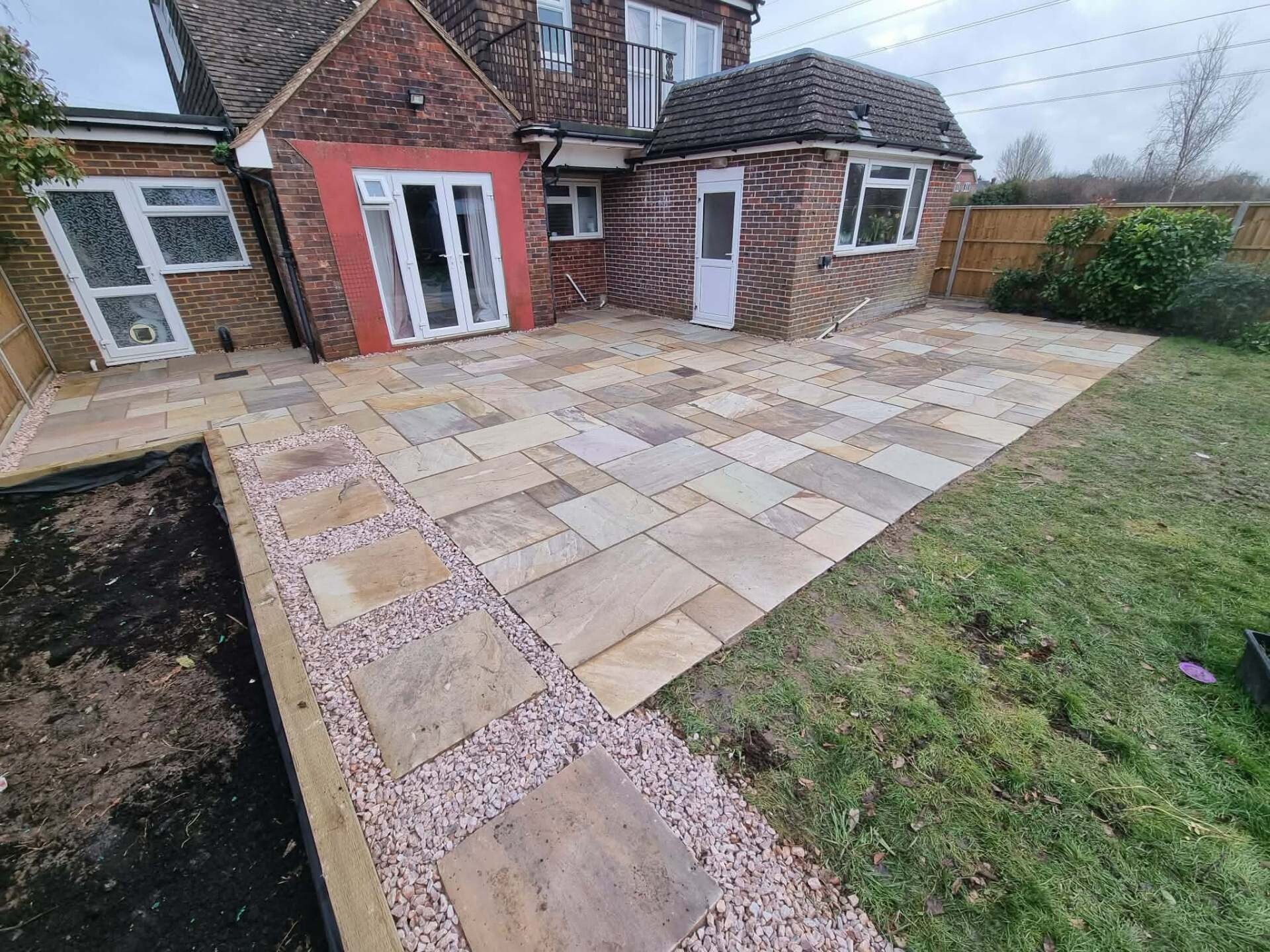 Cream sandstone patio finished beside a side return at a Worthing property.