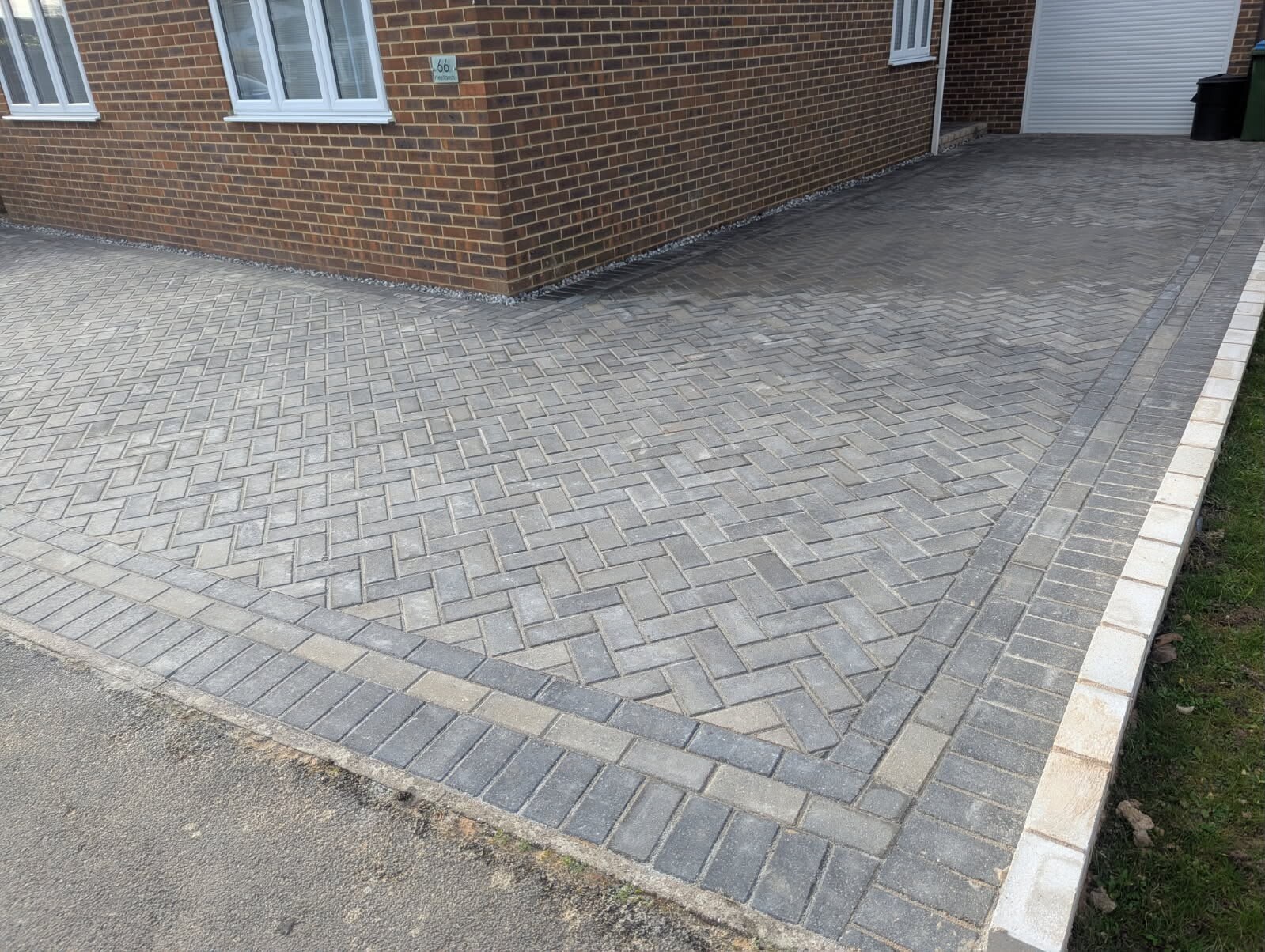 Hand-laid herringbone block paving driveway with clean edge course, installed by Heavens Property Solutions in West Sussex.